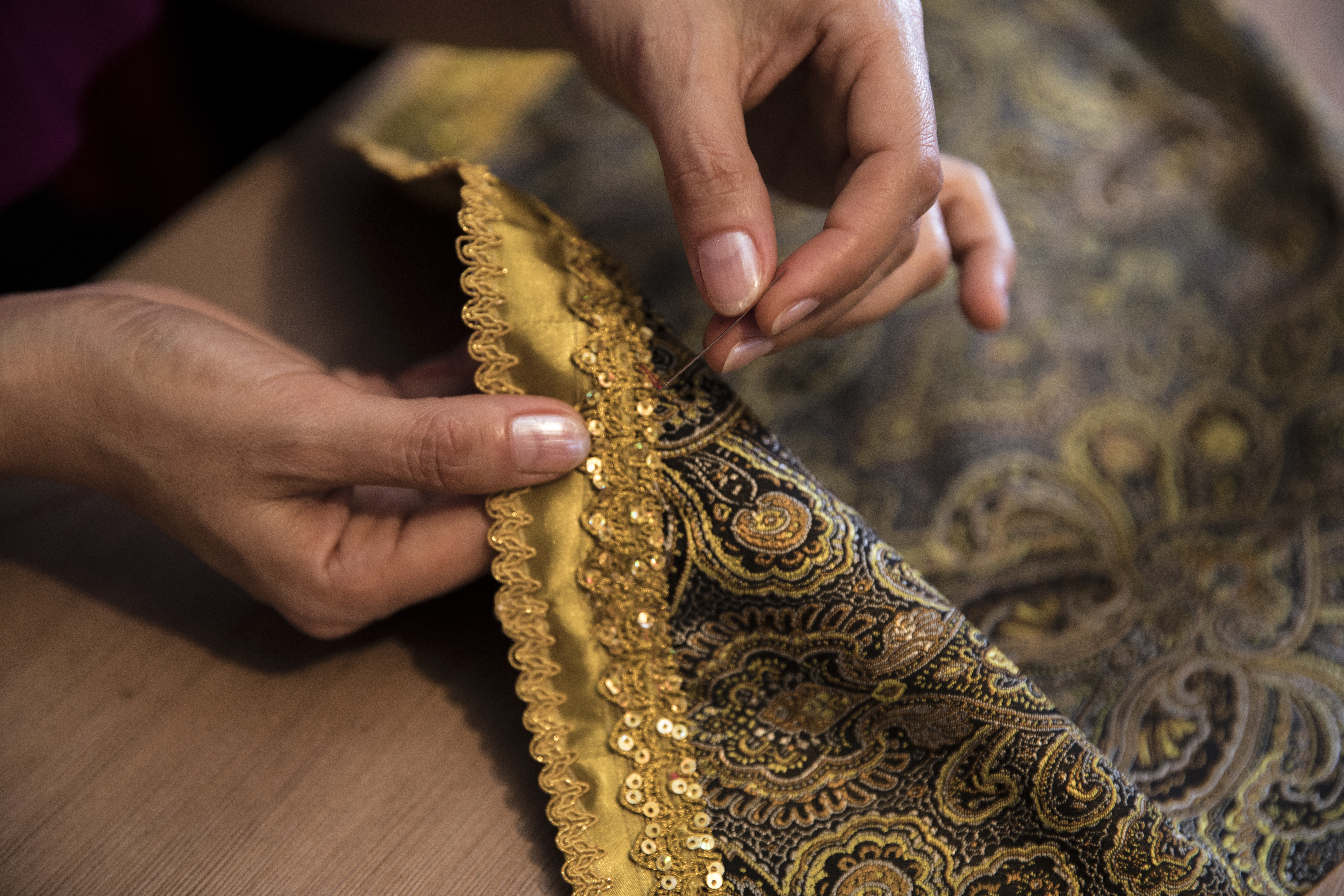 Artisan hand stitching a saree